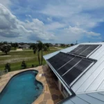 Solar panels installed on a roof overlooking a backyard pool