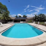 Backyard residential swimming pool with patio and landscaping