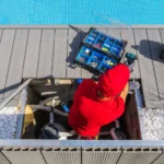 Technician servicing solar pool heating equipment on a rooftop