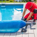 Person covering a swimming pool with a pool cover