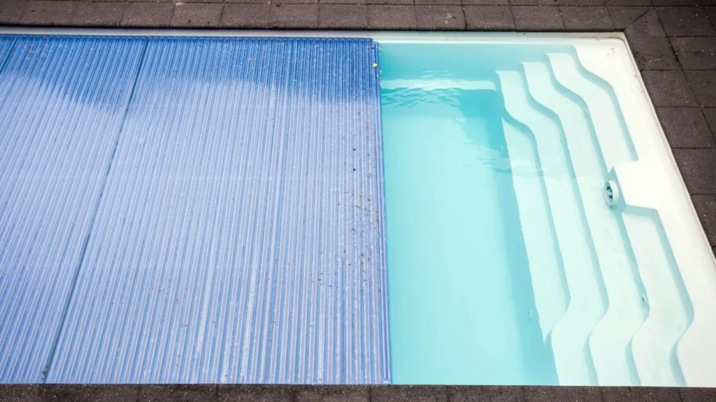 Solar pool heating mat installed beside a residential swimming pool