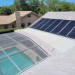Solar pool heating panels installed beside a backyard swimming pool