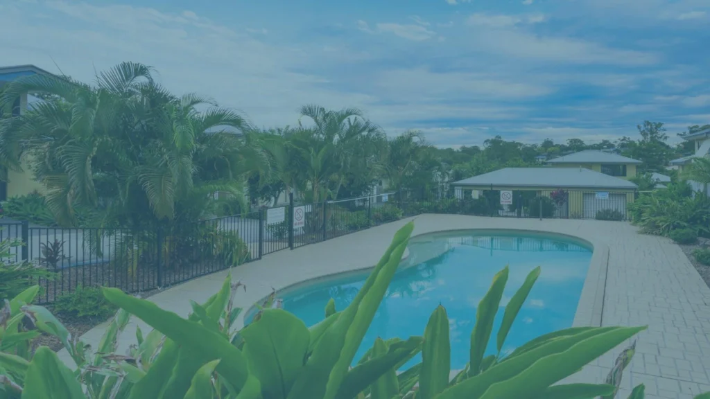 Residential backyard pool surrounded by tropical landscaping