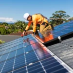 Worker installing or adjusting solar panels on a rooftop