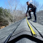 Technician measuring a roof during solar panel removal for re-roofing